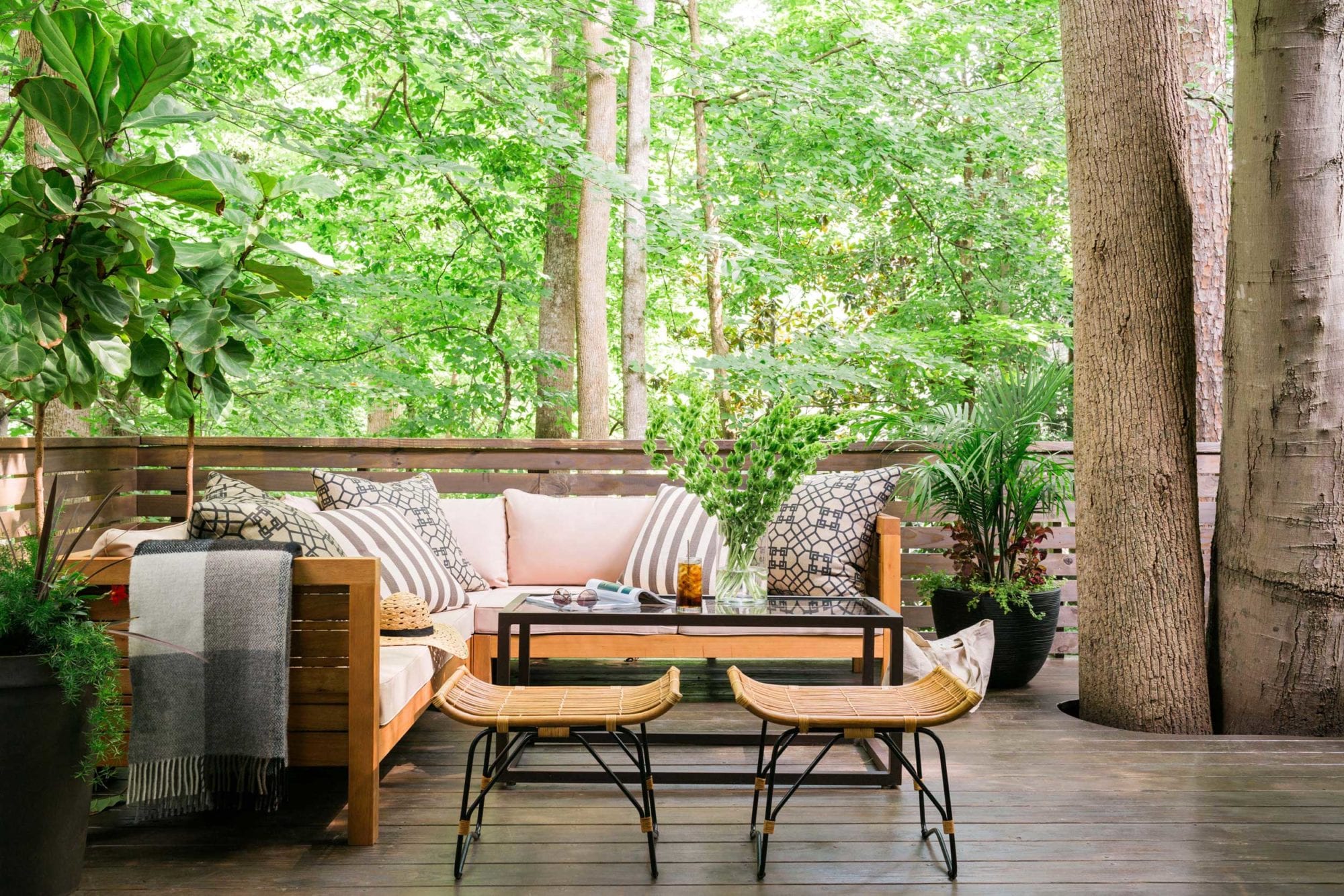 An outdoor pressure-treated wood deck built around trees